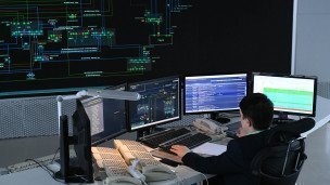 Инженер в диспетчерской перед мониторами 