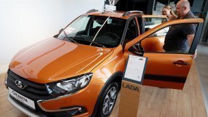 Семейная пара в автосалоне LADA выбирают автомобиль