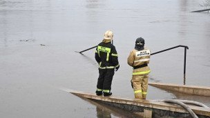 Сотрудники МЧС наблюдают за разлившейся рекой