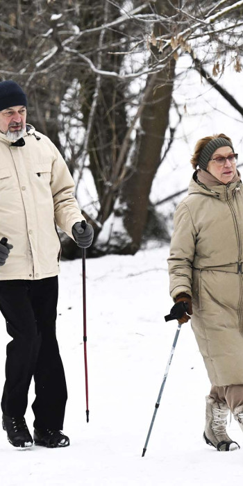 мужчина и женщина гуляют в парке зимой