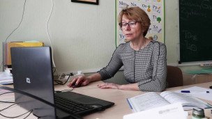 Учитель в классе за ноутбуком