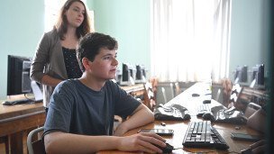 Молодой человек заполняет необходимые данные для подачи документов на компьютере 