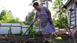 Женщина работает на участке