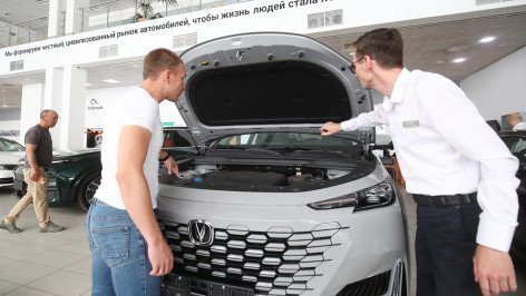 Покупатель осматривает автомобиль в автосалоне