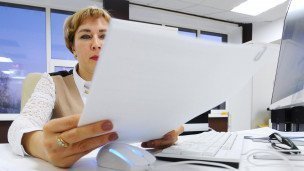 Сотрудник в офисе с листом бумаги