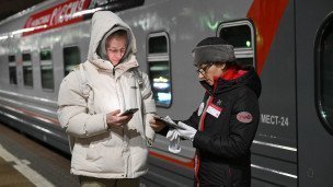 Проводница проверяет документы пассажира перед посадкой на поезд 