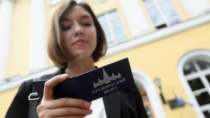Девушка держит в руках студенческий билет 