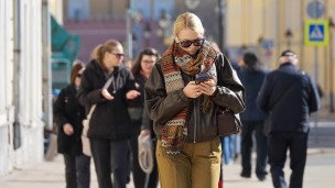Девушка с телефоном идет по улице 