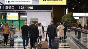Люди с чемоданами в аэропорту идут на посадку на международные рейсы