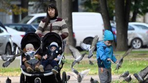 Женщина с коляской в парке