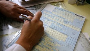 Медсестра  заполняет больничный лист 