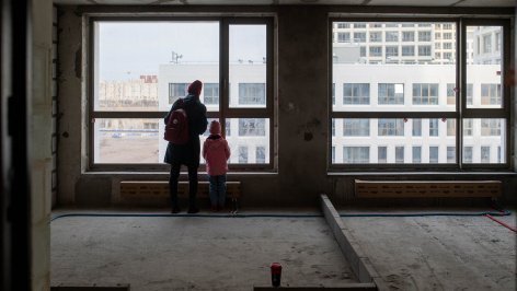 Родитель с ребенком во время приемки квартиры в новостройке