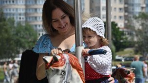 Женщина с ребенком на карусели
