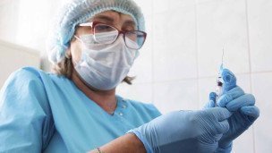 шприц с вакциной в руках у медработника