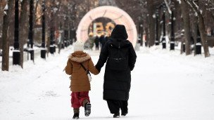 Женщина с ребенком идут по парку