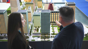 мужчина и женщина рассматривают макет нового жилого района