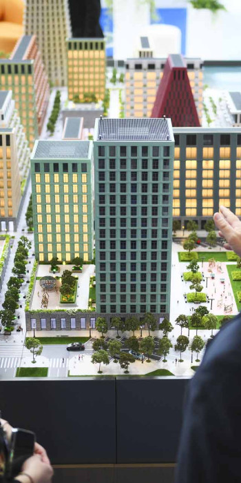 мужчина и женщина рассматривают макет нового жилого района