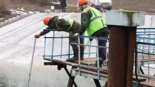 Рабочие замеряют уровень воды