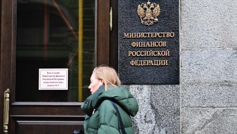 Женщина проходит мимо здания министерства финансов