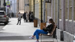 Девушка отдыхает на новой скамейке на улице