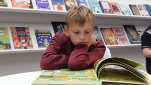 ребенок читает книгу 