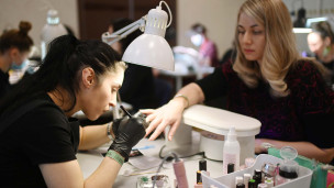 Мастер по ногтям делает маникюр 