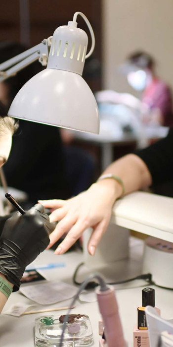 Мастер по ногтям делает маникюр 