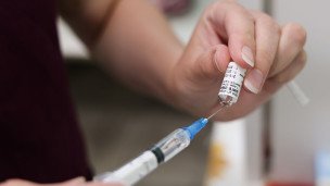 Шприц с вакциной во время профилактической вакцинации 